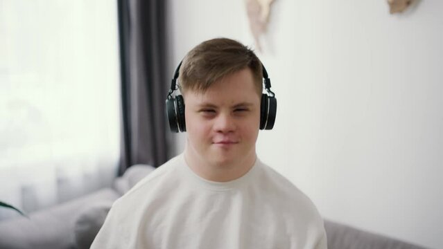 A guy with down syndrome having great time on the living room at home listening music