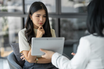 Confident young Asian woman wondering online job inquiries Financial and business management systems with professionals who train and learn at the office.