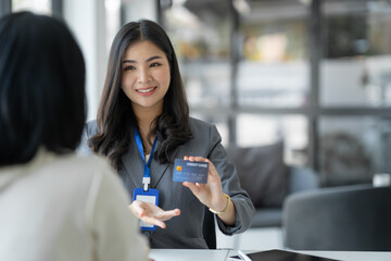 Young businesswoman, company employee presenting a form of credit limit, benefits, how to use the card , coverage amount, insurance ,interest rate to customer for choice. Payment. Loan concept.