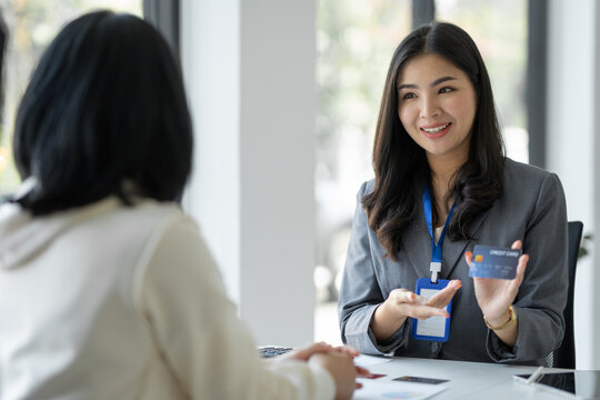 Young businesswoman, company employee presenting a form of credit limit, benefits, how to use the card , coverage amount, insurance ,interest rate to customer for choice. Payment. Loan concept.