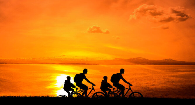 four 4 bikers - men and girls. family of black silhouette of fathers and daughters in sunrise isolated on yellow evening sky background. grass. team, group of people ride on bicycles. parents and kids
