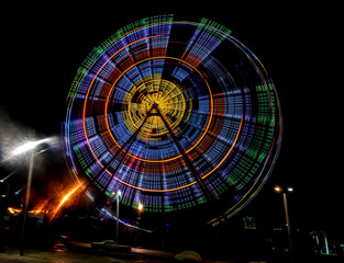 illumination of Ferris wheel in motion at the amusement park, night scene. bright colorful illumination. Long exposure shot. BATUMI, Adjara, GEORGIA. nightlife. isolated on black background.