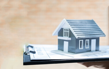 home model in Real estate agent hand and explain the business contract, rent, buy mortgage, loan, or insurance
