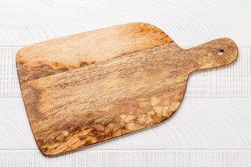 Wooden cutting board on white kitchen table