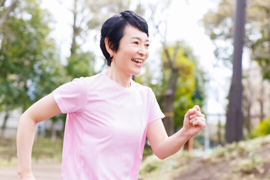 公園でジョギングする成熟した日本人女性