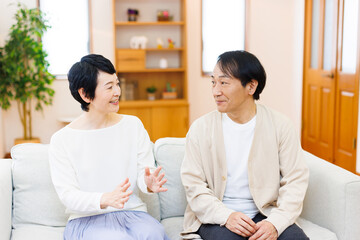 家でおしゃべりをする成熟した日本のカップル
