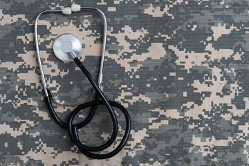 Closeup of a doctors stethoscope laying on old Military camouflage background