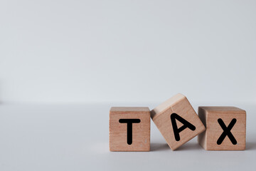 Three Wooden cubes arrange with TAX word over white background use for...
