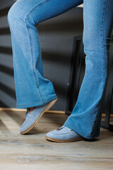 Slender female legs in jeans and blue loafers. Collection of summer women's shoes. Stylish women's...