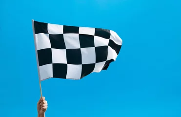 Poster Im Rahmen Human hand waving checkered flag on blue background © xy