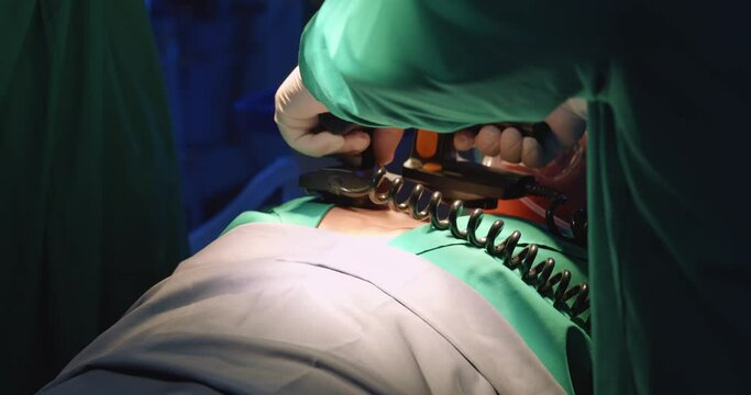 A doctor using defibrillator to pump at chest of unconscious with low heart rate patient to save life.