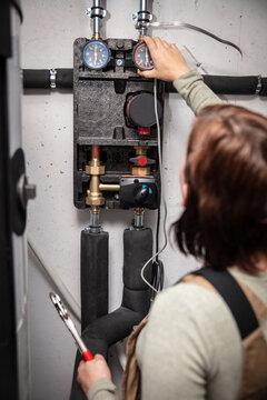 female plumber with a pellet heating system in the basement