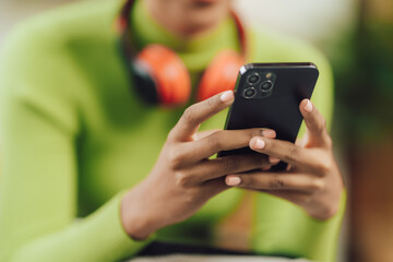 Focused young African female college student working on a laptop on living room.