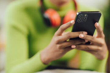 Focused young African female college student working on a laptop on living room.
