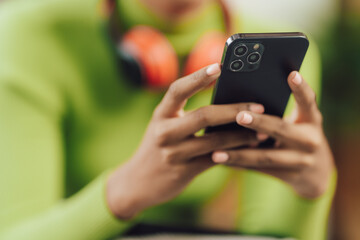 Focused young African female college student working on a laptop on living room.