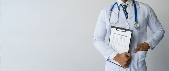 male doctor wearing white long-sleeved medical uniform with heart rate monitor. medical file stand...
