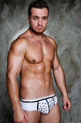 Young handsome stripper posing in the studio. A man with an athletic body dressed as a police...