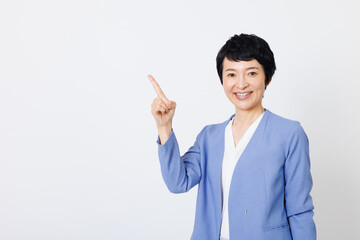 成熟した日本人女性は笑顔でポインティングしています