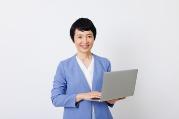 ラップトップ付きのスマートカジュアル服を着た成熟した日本人女性