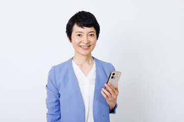 携帯電話付きのスマートカジュアル服を着た成熟した日本人女性