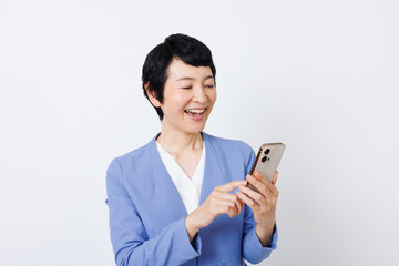 携帯電話付きのスマートカジュアル服を着た成熟した日本人女性