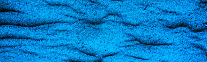 Fototapeta na wymiar Abstract wavy sandy background. Texture of sand in desert or on the beach. Horizontal banner Blue toning