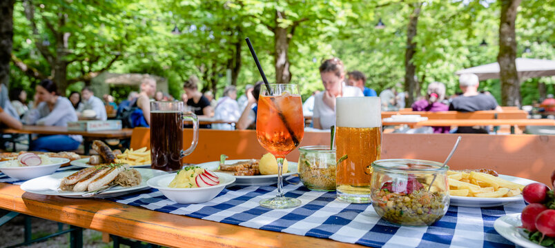 Genuss im Biergarten: Frisches Bier und Aperol Spritz auf Tisch im Sommer