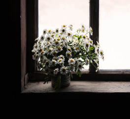 Bouquet of daisies on the windowsill