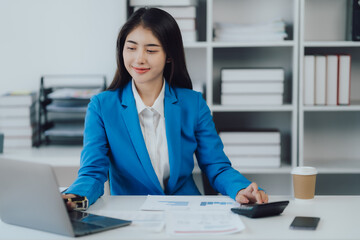 Young charming businesswoman sitting at her desk with laptop computer on the table.