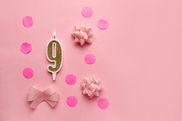 Number 9 on pastel pink background with festive decor. Happy birthday candles. The concept of celebrating a birthday, anniversary, important date, holiday. Copy space. Banner