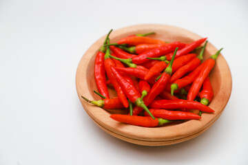 Top view  red chilies on a wooden plate on a white background