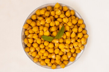 On the table Fresh boiled chickpeas on a plate and in a wooden spoon .