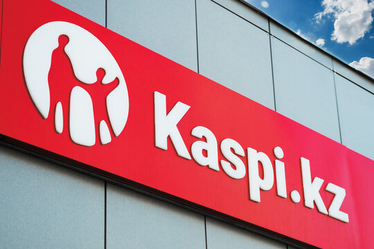 A signboard with the Kaspi Bank logo on the building above the entrance group. Almaty, Kazakhstan - March 23, 2023