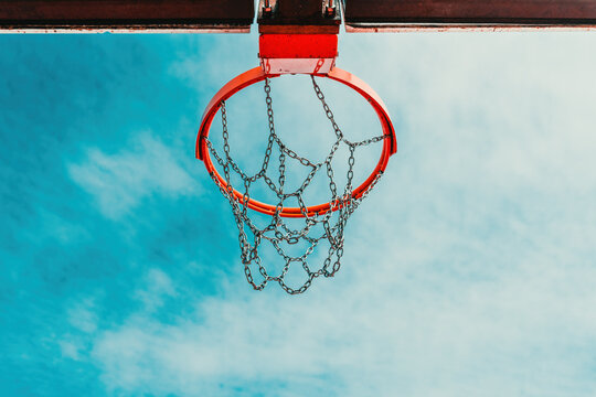 Low-angle view of an outdoor basketball hoop with a chain net