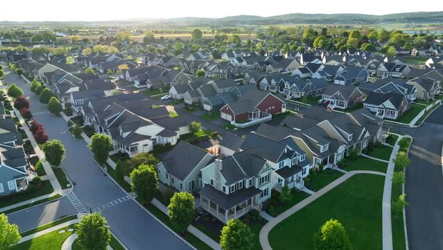 Houses in new development in spring. High aerial establishing shot of sprawling retirement community with beautiful sunset light. American housing theme.