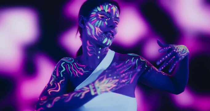 Young Beautiful Girl Embodies Modern Dance with Colorful Neon Paint on Her Body in a Dark Studio, Creating Mesmerizing Visual Language and Vibrant Expressive Energy with Her Performance