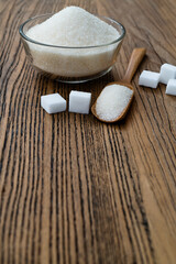 A bowl granulated sugar and sugar cubes on the table