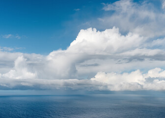 Beautiful tropical sunny summer day seascape with big white cumulus clouds in sky over blue sea water. Nature background or texture.