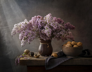 Still life with a bouquet of lilacs and walnuts on a wooden table near the window