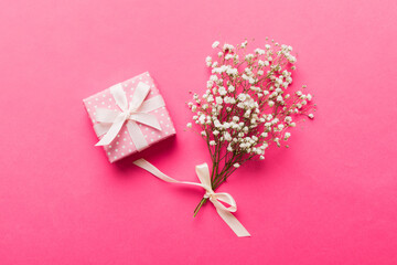Gift or present box and flower gypsophila on light table top view. Greeting card. Flat lay style with copy space