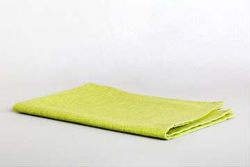 top view with green kitchen napkin isolated on table background. Folded cloth for mockup with copy space, Flat lay. Minimal style