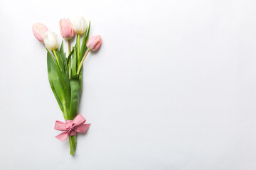 Bouquet of pink tulips on colored table background . Top view with copy space. Waiting for spring. Happy Easter card. Flat lay