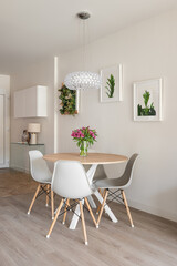 Modern stylish living room with a round dining table, console and decorative accessories on the walls. Hotel concept in a hotel with a five-star service
