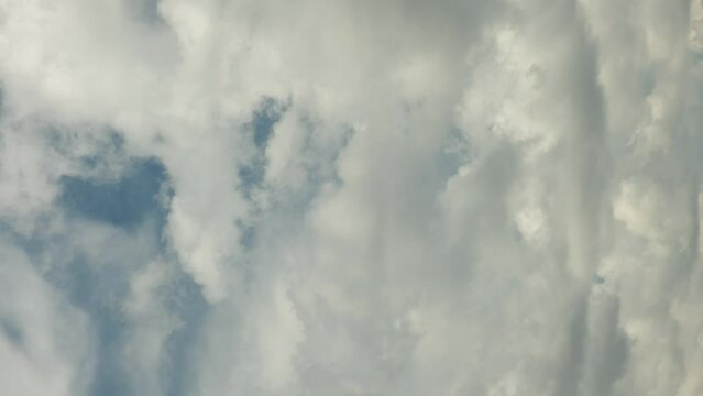 Dramatic time-lapse of moving white clouds in stormy sky. Timelapse of dynamic cloudscape in dramatic sky, vertical video