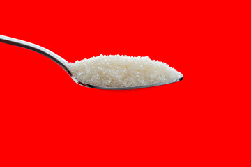 Spoon with sugar crystals on black background