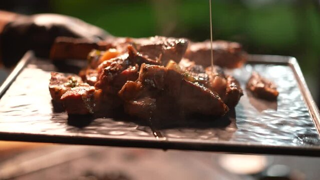Adding garlic sauce to cooked meat for barbecue, close up