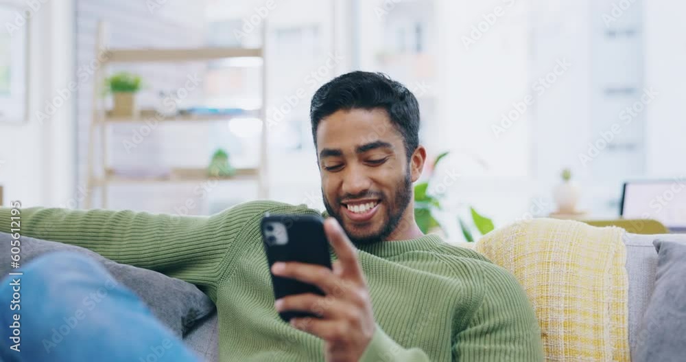 Sticker Phone, relax and happy man on sofa in living room for social media, networking and mobile app chat at home. Young Indian person with communication, reading online and internet post on couch or lounge