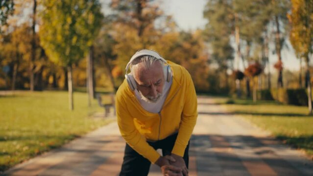 Senior man feeling acute knee pain while jogging in park, joint inflammation