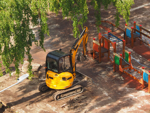 Mini excavator is carrying out work on the improvement of the urban area, medium plan, spring in the city. The work of municipal equipment in the city.