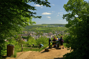 Eine Familie sitzt auf einer Parkbank und genießt die Aussicht auf die Stadt Echternach in Luxemburg.